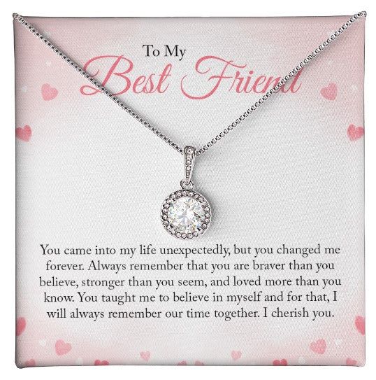 A round-cut cubic zirconia pendant necklace in white gold over a personalized 'To My Best Friend' sentimental message card with pink hearts