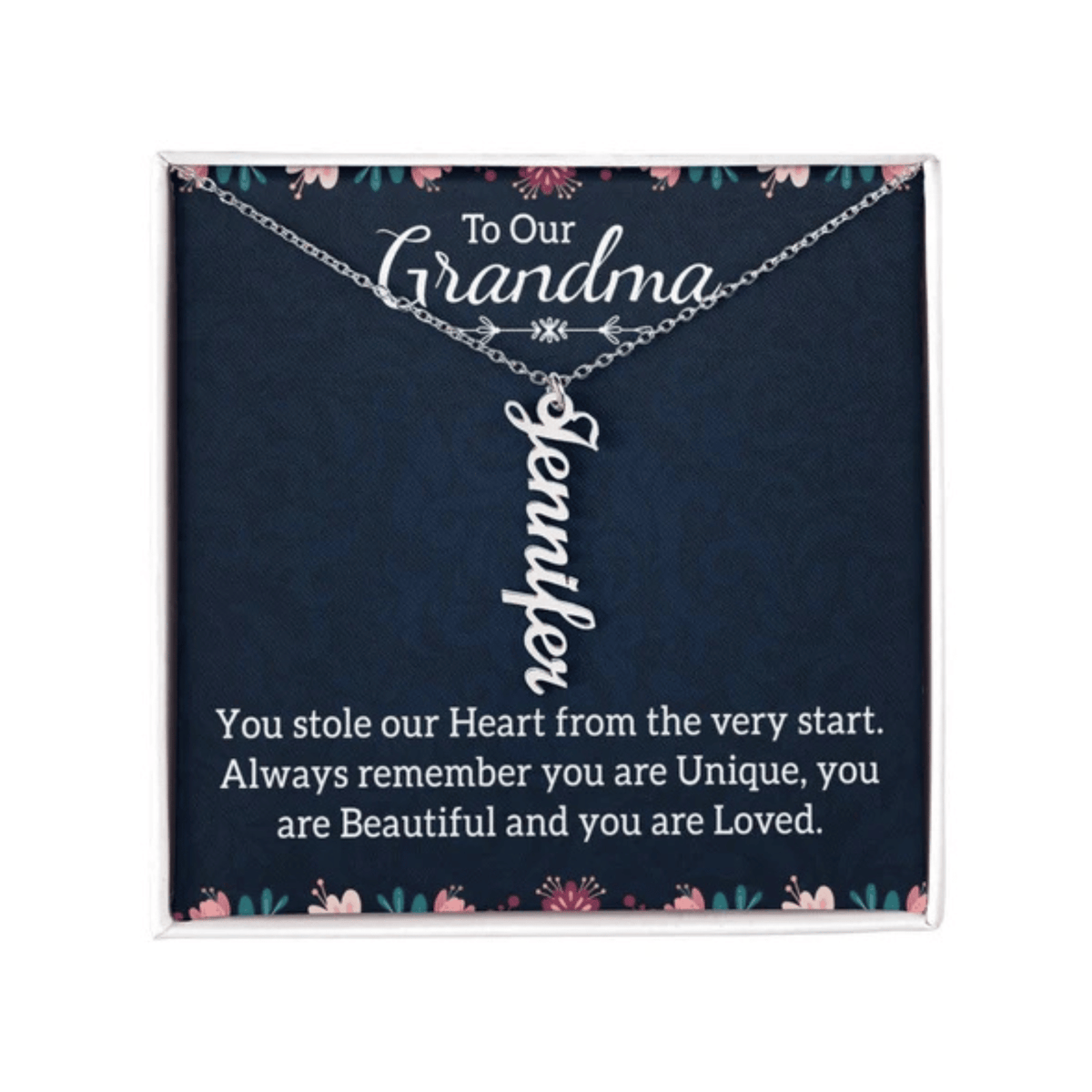 A pink and green floral jewelry card with a navy blue background, with a silver personalized vertical name necklace with text that says, "TO OUR GRANDMA".
