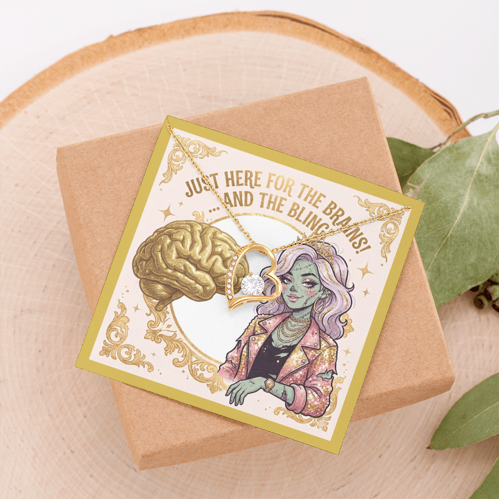 18k gold over stainless steel heart necklace with cubic zirconia gems on a gold zombie girl jewelry card, styled on top of a light beige jewelry box resting on light beige wood next to a green plant.