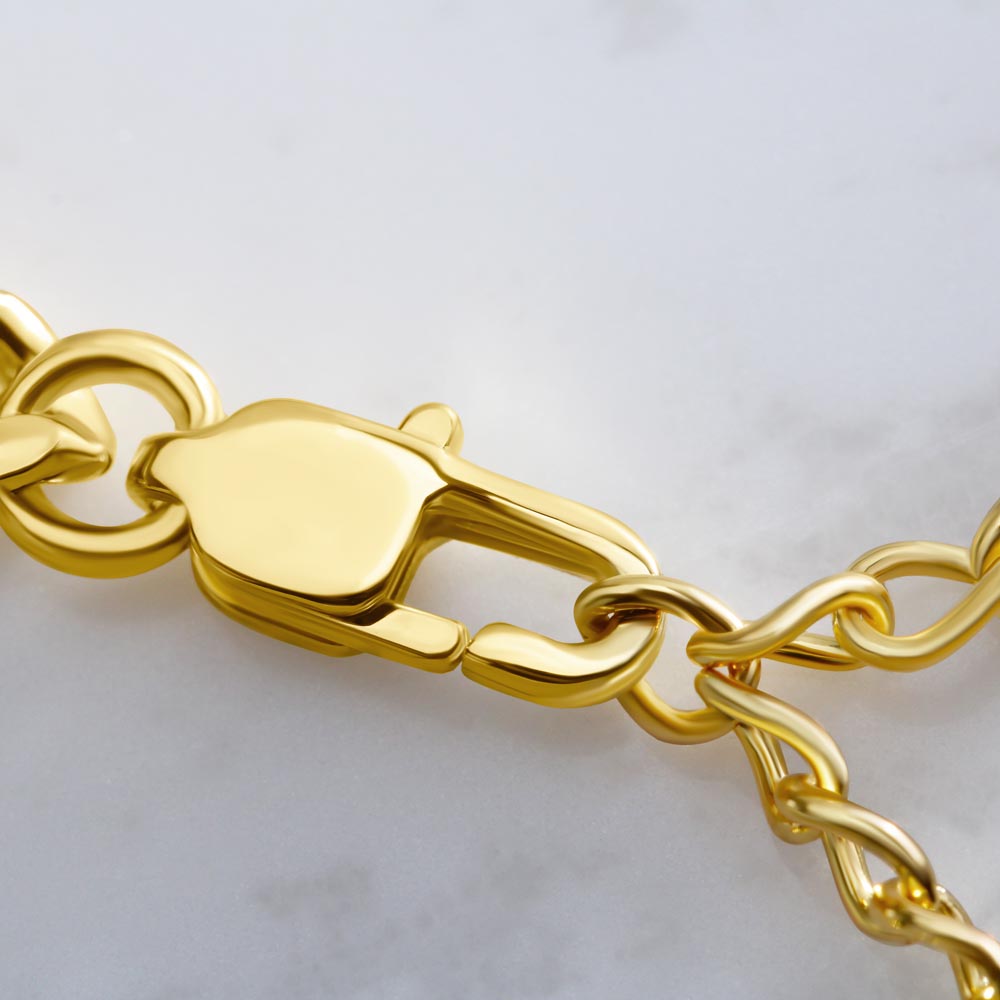 Close-up of a gold chain bracelet on a light gray background