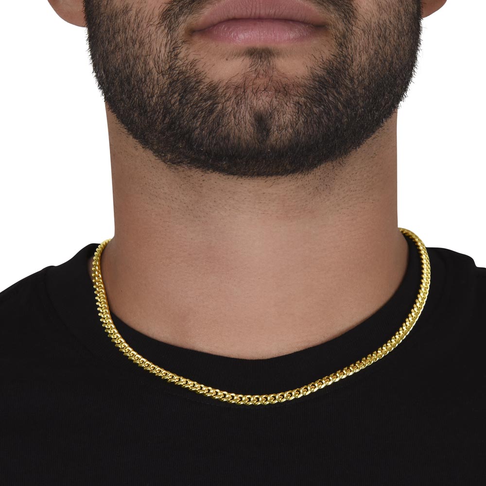 A man with a black shirt with a short black beard wearing a gold cuban link chain around his neck.