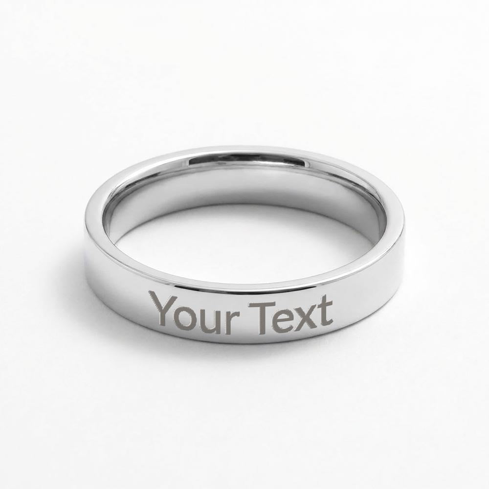 Polished silver stainless steel flat-profile band ring with sample engraving “Your Text” on a white background.