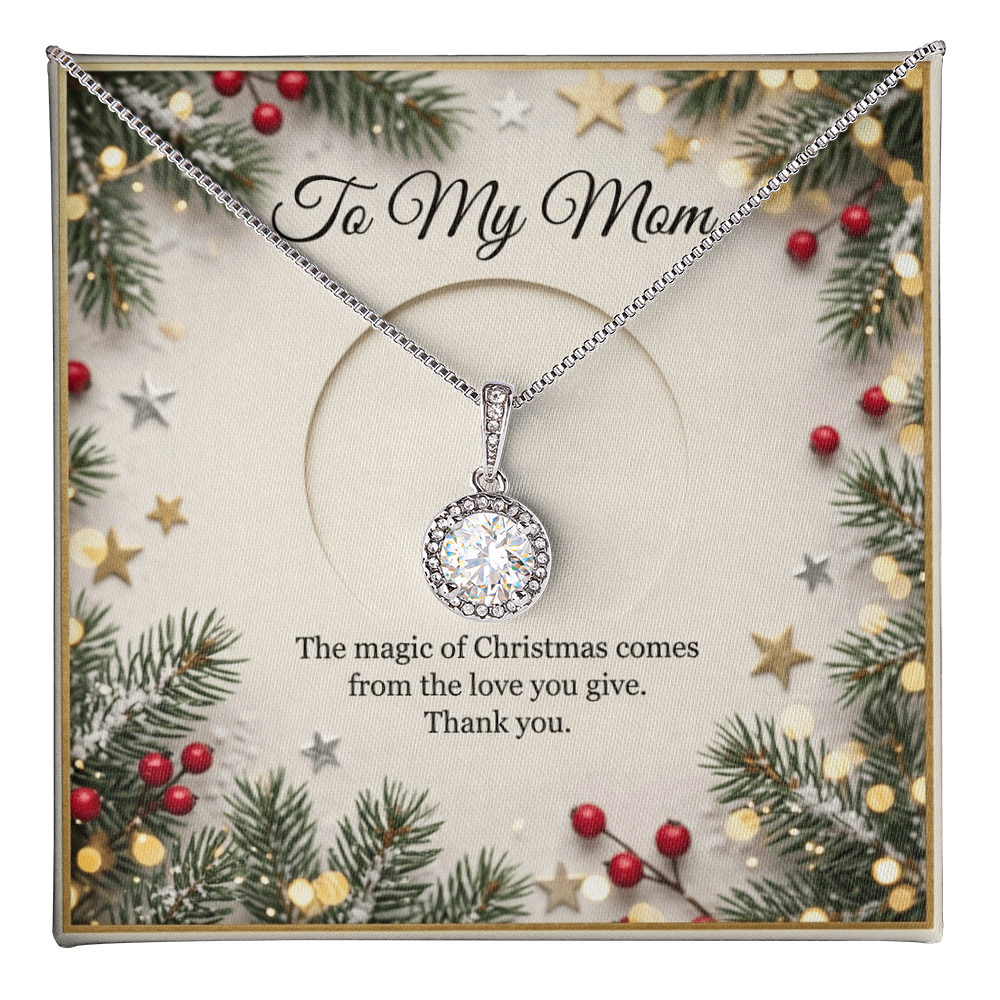 The card is framed by a festive border of evergreen pine branches, red winter berries, scattered gold and silver stars, and soft, glowing bokeh fairy lights. At the top of the insert card, elegant black cursive text reads "To My Mom." The silver necklace features a delicate chain that drapes downward to hold a round, brilliant-cut crystal pendant surrounded by a halo of smaller white stones.