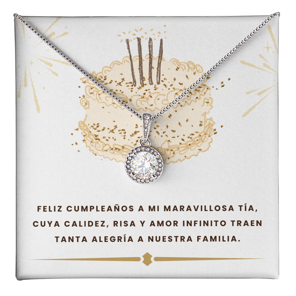Un collar plateado con un dije circular de cristal brillante, presentado sobre una tarjeta de regalo blanca. El fondo de la tarjeta muestra la ilustración de un pastel de cumpleaños dorado con tres velas y destellos. En la parte inferior, lleva el texto impreso en letras oscuras: "FELIZ CUMPLEAÑOS A MI MARAVILLOSA TÍA, CUYA CALIDEZ, RISA Y AMOR INFINITO TRAEN TANTA ALEGRÍA A NUESTRA FAMILIA".
