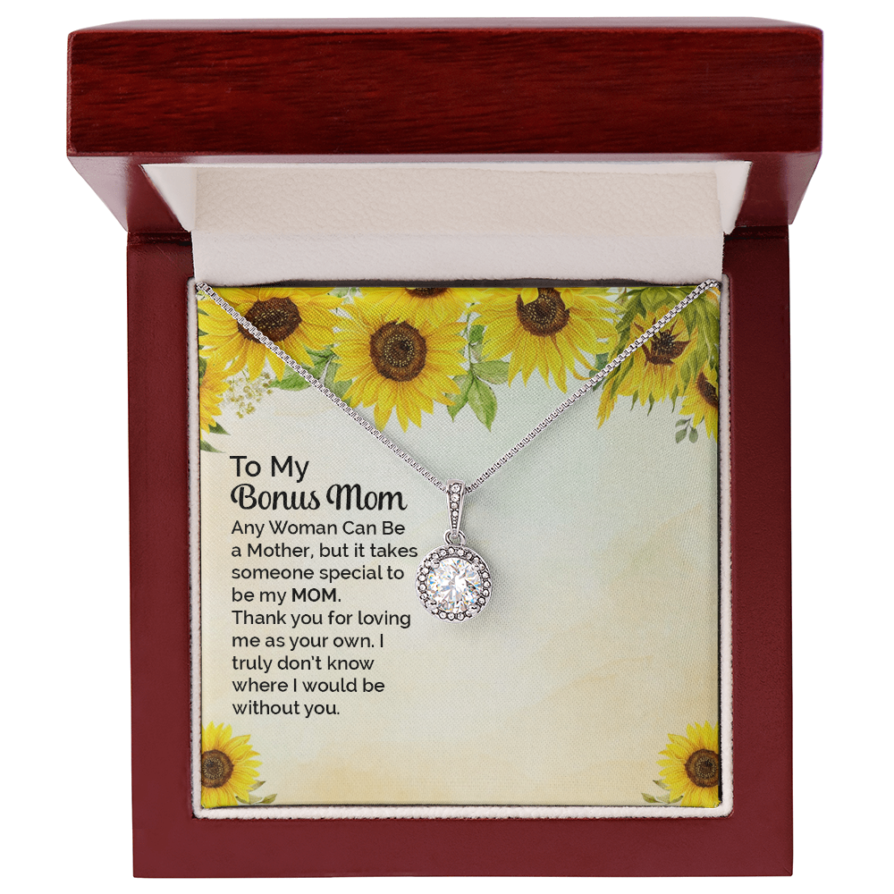 A silver necklace with a round bezel-set clear stone pendant is displayed on a printed gift card. The card has a sunflower border design and a sentimental message addressed to 'My Bonus Mom. the card and necklace is sitting is a dark red led lit gift box.