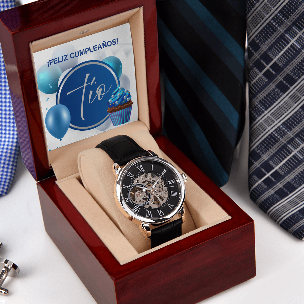 Reloj de pulsera analógico para hombre con correa negra y esfera mecánica a la vista, guardado en un estuche de madera abierta que incluye la tarjeta "¡Feliz Cumpleaños! Tío" en la tapa, colocado junto a corbatas elegantes de color azul y gris.