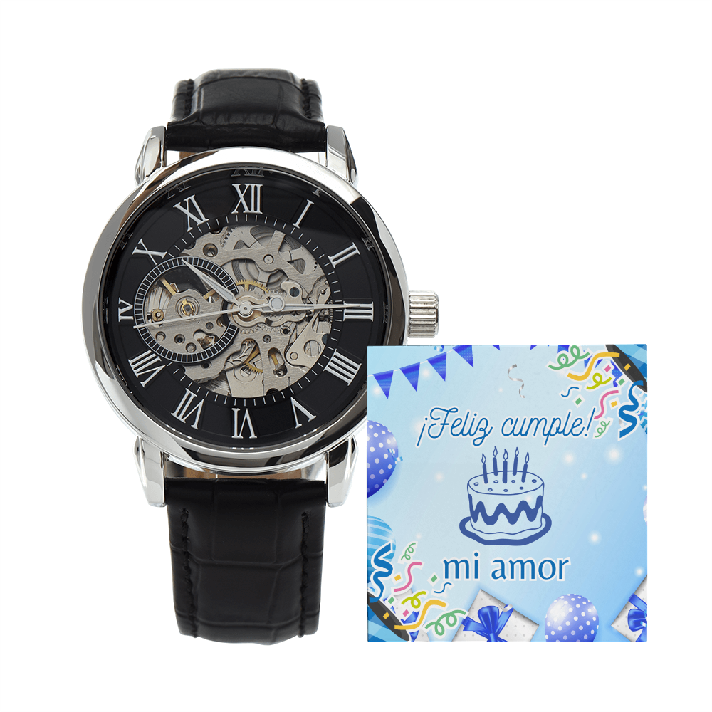 Reloj mecánico tipo skeleton para hombre con esfera negra, números romanos y correa de cuero texturizado negro, presentado junto a una tarjeta de cumpleaños azul que dice ¡Feliz cumple mi amor!