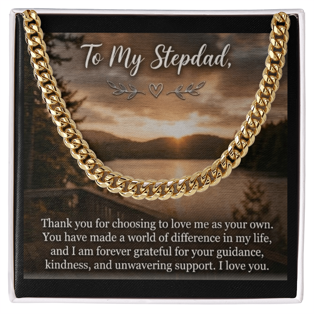 The card displays a scenic lakeside landscape at sunset or sunrise with dense pine trees lining the shores under a cloudy sky. At the top, the elegant script text reads, "To My Stepdad," adorned with a small heart and leaf flourishes underneath. The bottom half of the card features a heartfelt paragraph printed in a clean, white serif font. A gold men's cubic link chain rests on the image.