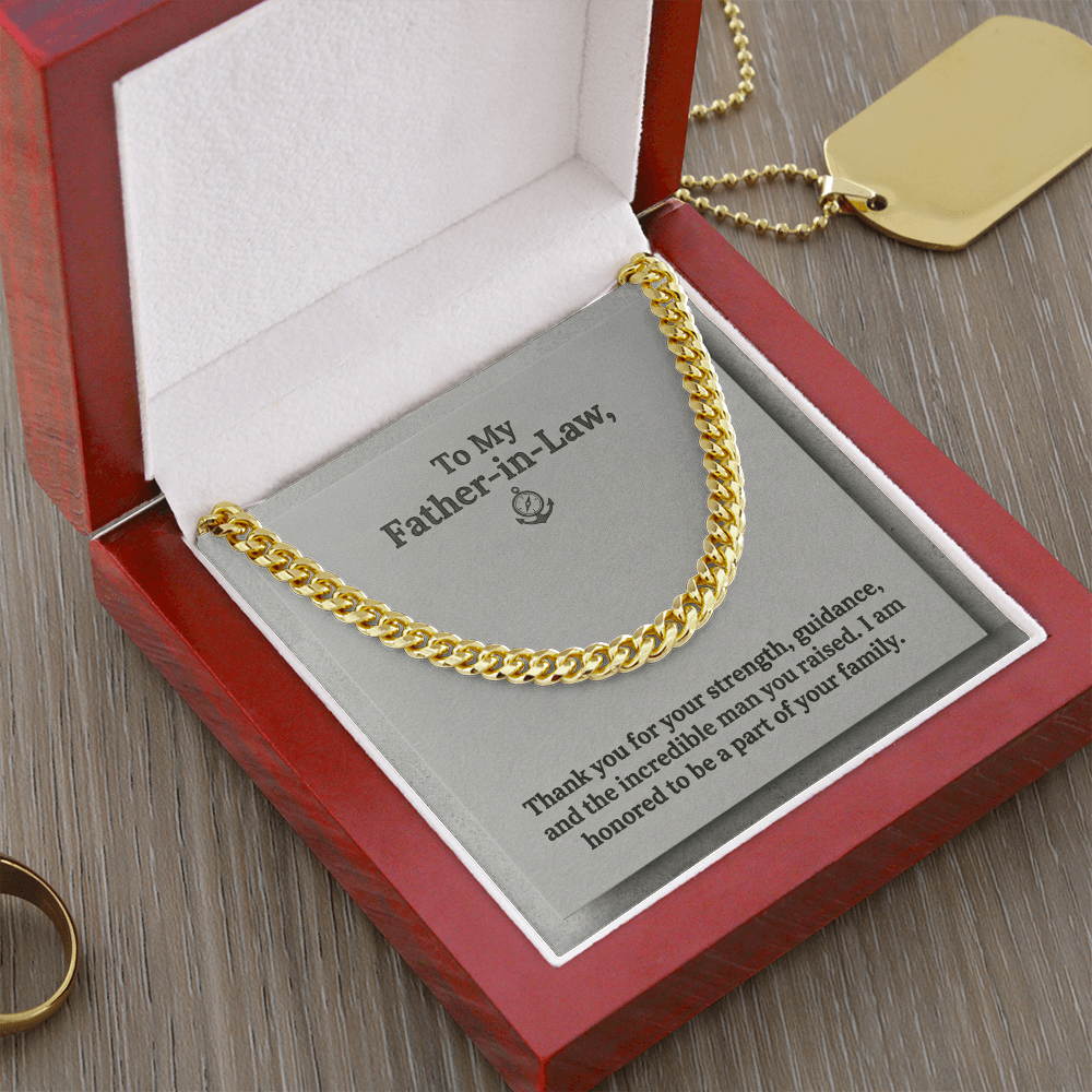 A gold-toned men's Cuban link chain necklace displayed inside an open luxury wooden gift box with a white interior. The necklace sits on a grey message card featuring a small anchor and compass logo and the printed text: "To My Father-in-Law, Thank you for your strength, guidance, and the incredible man you raised. I am honored to be a part of your family."