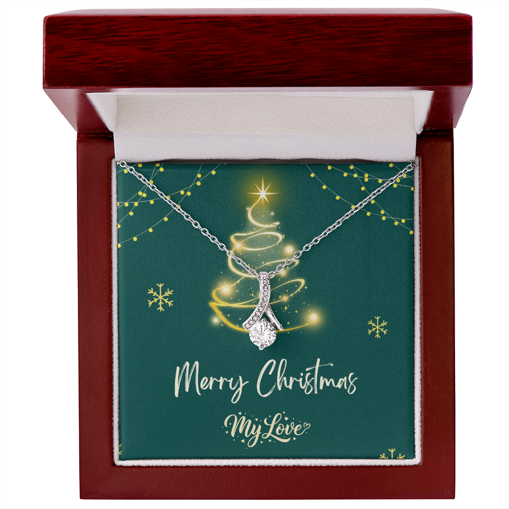 A silver Christmas tree pendant necklace with a sparkling clear teardrop-shaped center stone, presented on a dark green square gift card inside a dark red wood gift box. The card features a gold glittery Christmas tree, snowflakes, and the text 'Merry Christmas My Love."