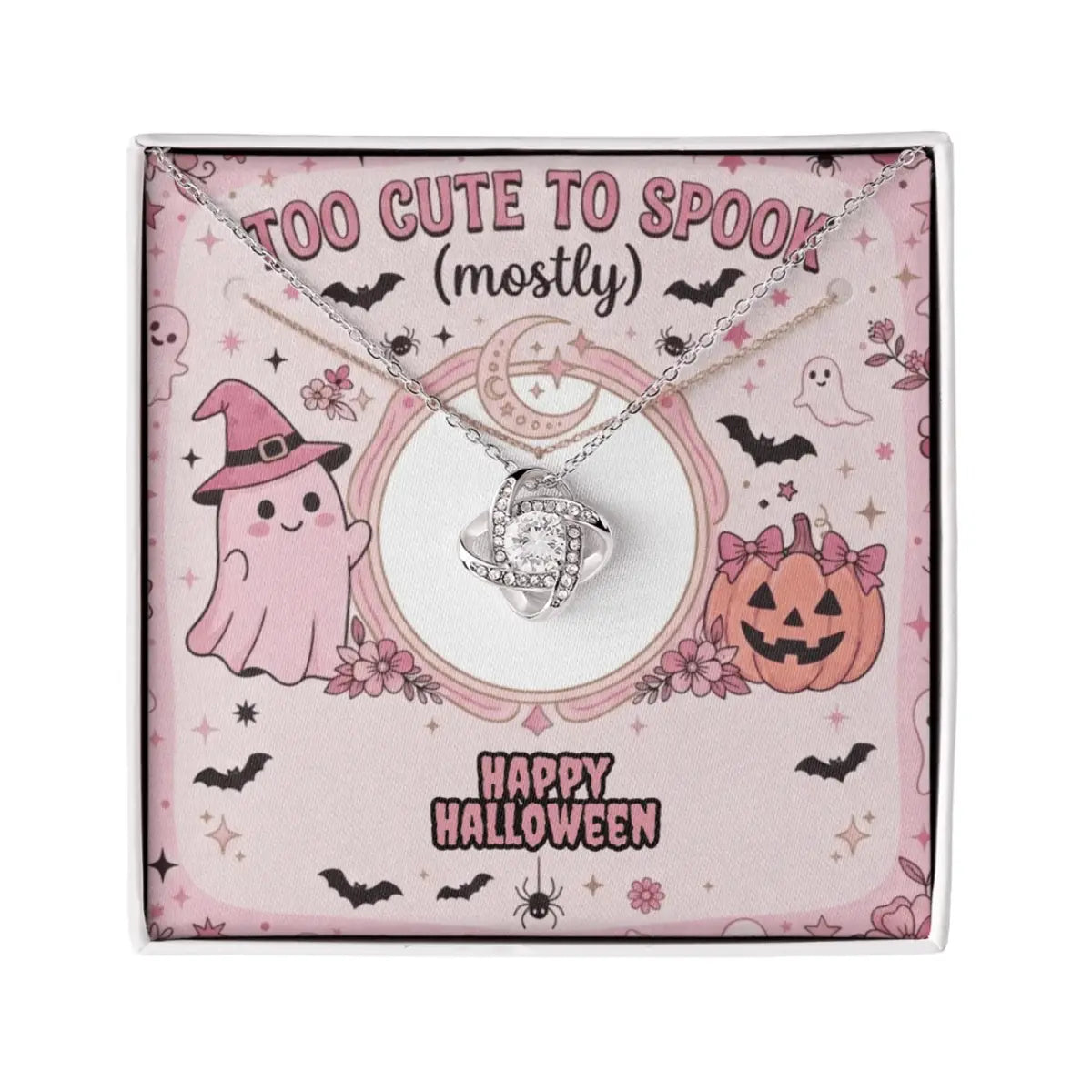 A silver-toned necklace with a knot-shaped cubic zirconia pendant, presented on a pink Halloween-themed gift card that reads 'Too Cute to Spook (mostly)' and 'Happy Halloween'.