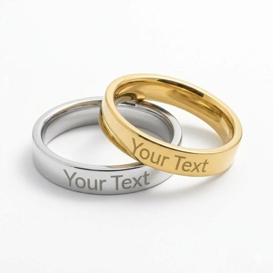 Two polished metal bands, one silver-toned and one gold-toned, overlapping on a white background. Both rings are engraved with the placeholder text 'Your Text'.