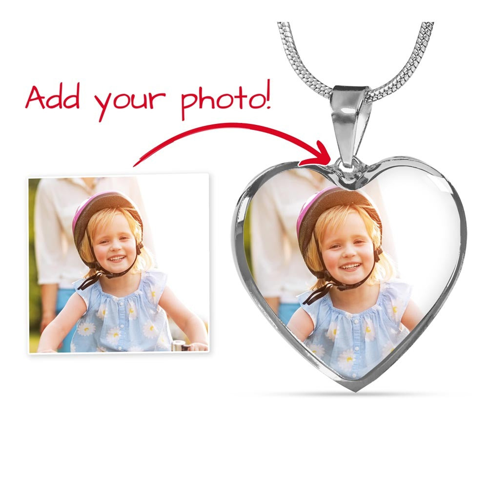 personalized  heart photo necklace in silver with an engraved back, showing how a picture of a smiling child is embedded into the pendant as a personalized jewelry gift for a wife or mother.