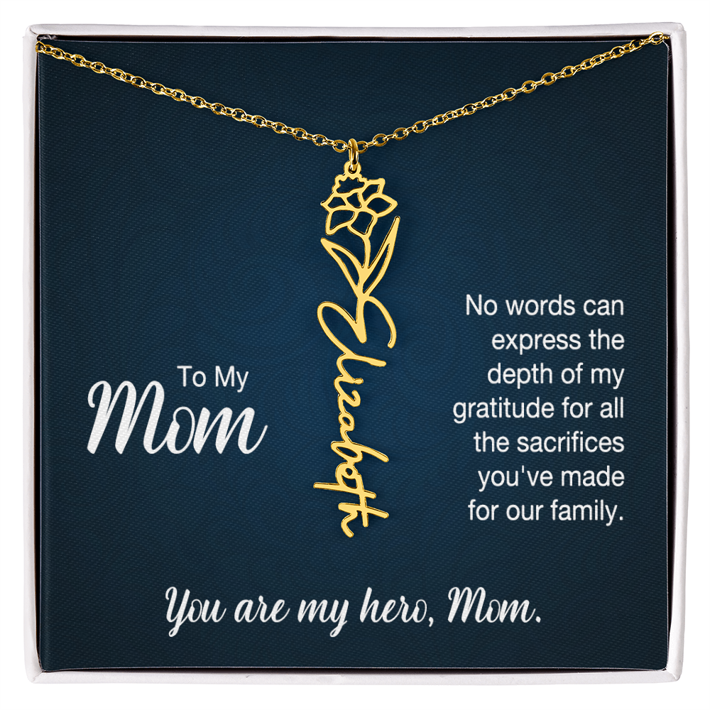 A gold floral filigree necklace with the name 'Elizabeth' engraved, presented on a dark blue gift card with sentimental text for 'Mom', in a standard black and white soft touch gift box.