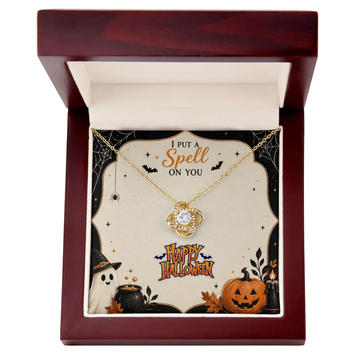 A gold necklace with a cat-shaped pendant is presented in an open dark red gift box. The necklace is displayed on a decorative Halloween-themed insert card that reads 'I PUT A Spell ON YOU' and 'Happy Halloween,' with illustrations of a ghost, pumpkin, and cauldron.