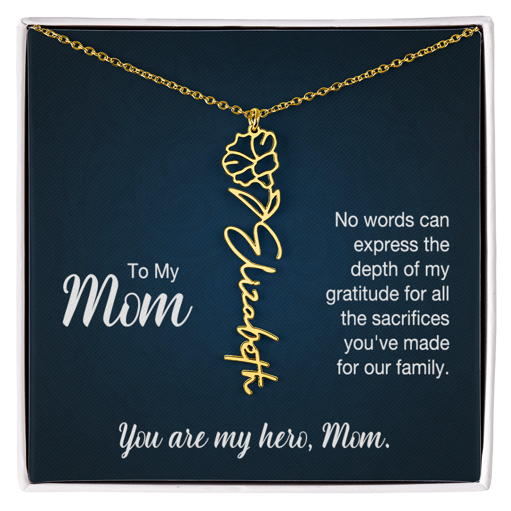 A gold floral filigree necklace with the name 'Elizabeth' engraved, presented on a dark blue gift card with sentimental text for 'Mom', in a standard black and white soft touch gift box.