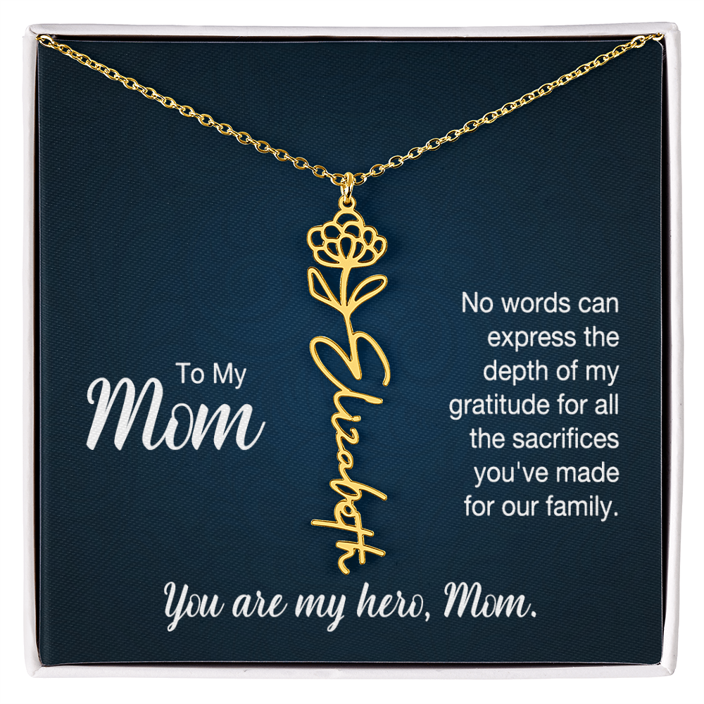 A gold floral filigree necklace with the name 'Elizabeth' engraved, presented on a dark blue gift card with sentimental text for 'Mom', in a standard black and white soft touch gift box.