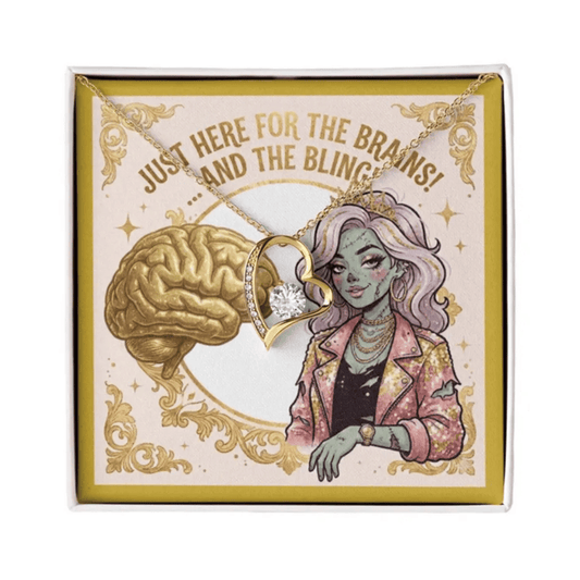 A gold heart-shaped pendant necklace with a clear crystal center, displayed on a square illustrated gift box. The box features a cartoon-style illustration of a woman with purple hair and a gold brain graphic, with the text 'JUST HERE FOR THE BRAINS! .