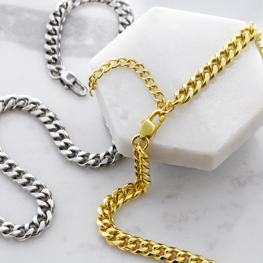 Gold and silver chain necklaces on a marble surface
