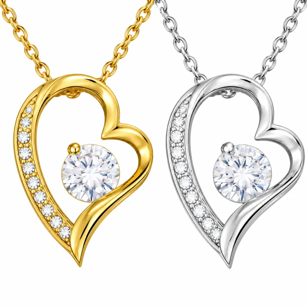 a gold tone heart necklace with clear stone and a silver tone heart necklace with sparkling crystal stone with multiple stones illuminating the piece.