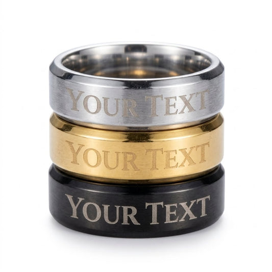 Three stacked custom engraved rings in silver, gold, and black finishes with 'YOUR TEXT' printed on the front, set against a plain white background.