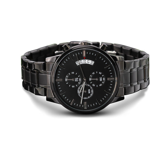 A men's military-style black chronograph watch featuring a matte black dial face and a matching black stainless steel link bracelet. The watch includes three functional sub-dials, white tick indices, a multi-date calendar display window on the top right, and side push buttons.