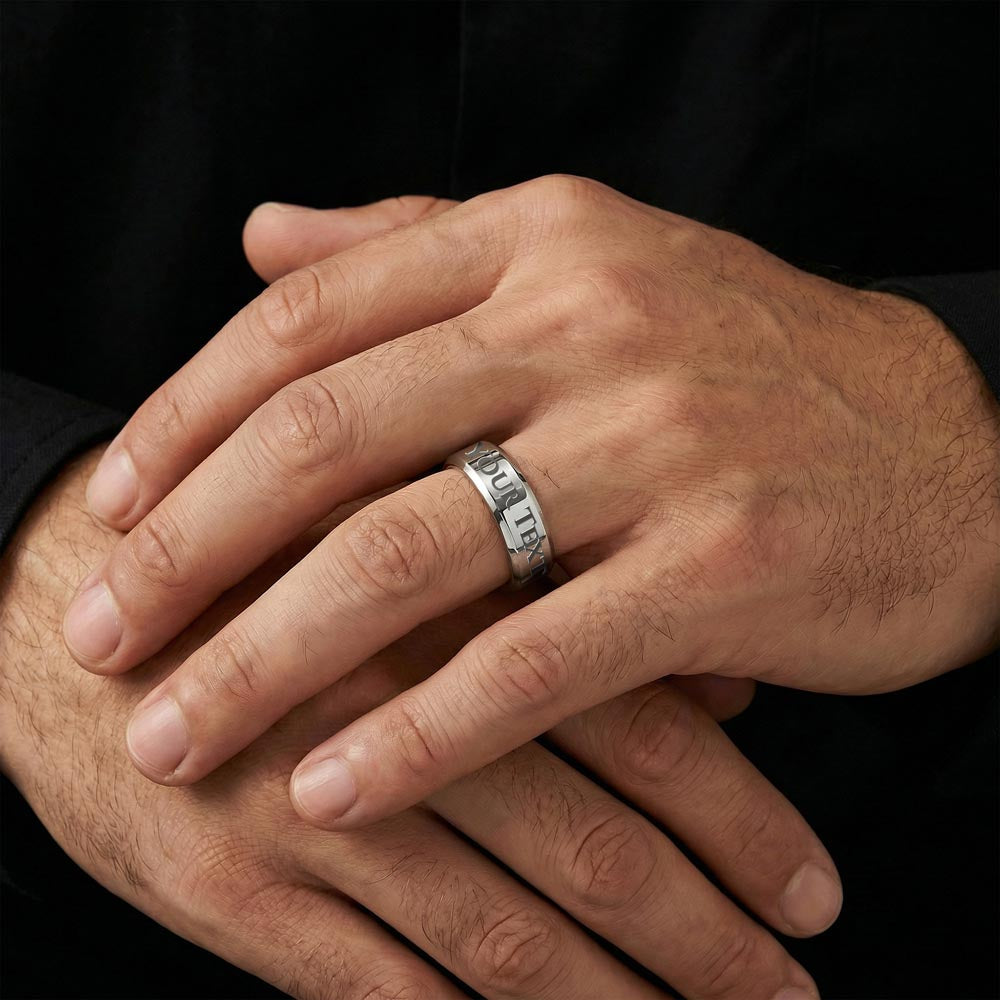 A pair of men's hands wearing a silver stainless steel ring that says YOUR TEXT.