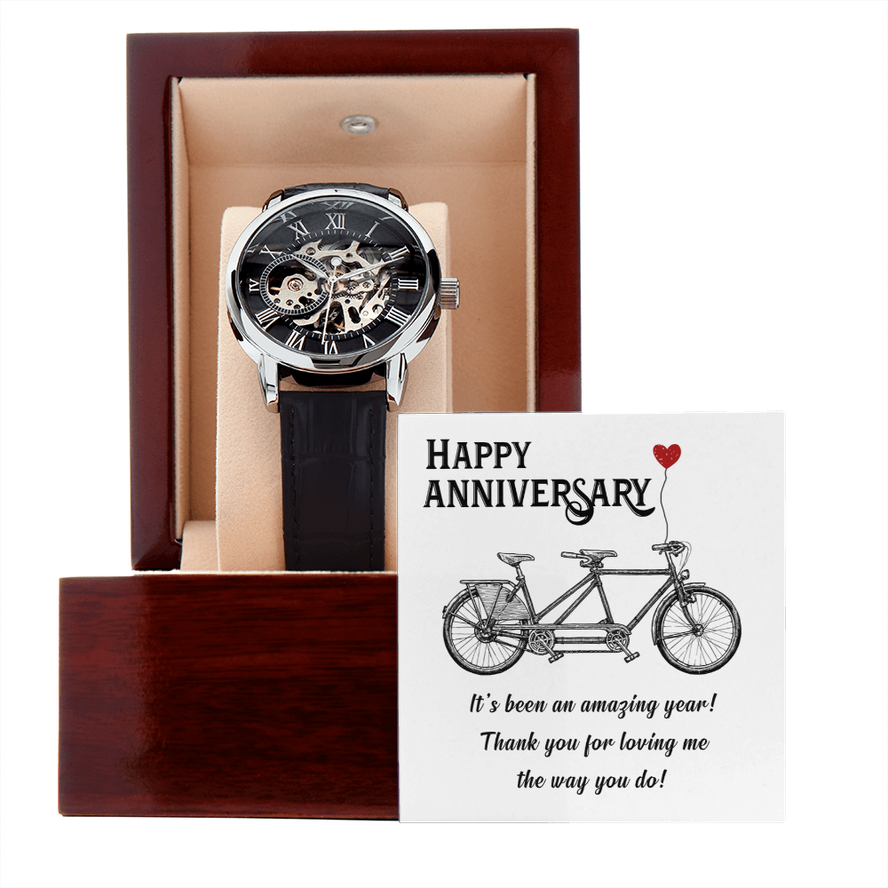 Men's openwork skeleton automatic watch with stainless steel casing and genuine leather band, displayed inside an illuminated luxury mahogany gift box with a soft LED spotlight shining down onto a personalized sentimental message card for a husband or boyfriend.