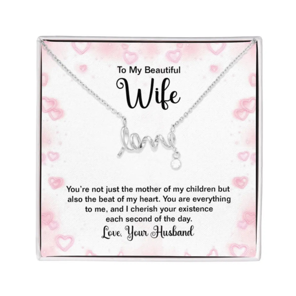 Silver necklace with a cursive 'love' pendant displayed on a pink heart-patterned gift card with a sentimental message for a wife, presented in a clear square box.