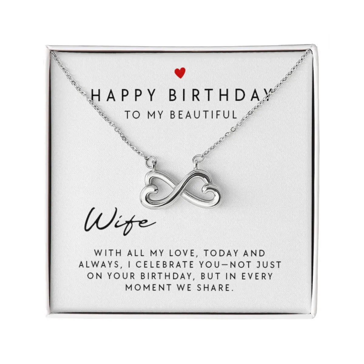 A silver infinity heart necklace presented on a white square gift card that reads 'HAPPY BIRTHDAY TO MY BEAUTIFUL Wife' with a small red heart and sentimental message, photographed on a white background.