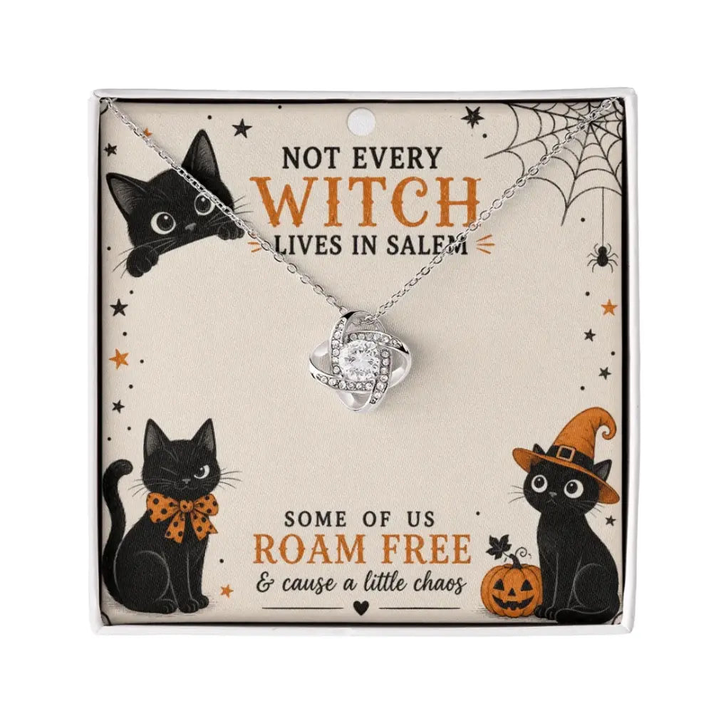 A silver witch hat pendant necklace with a clear rhinestone center, displayed on a themed Halloween card featuring black cats, spiderwebs, and orange text.