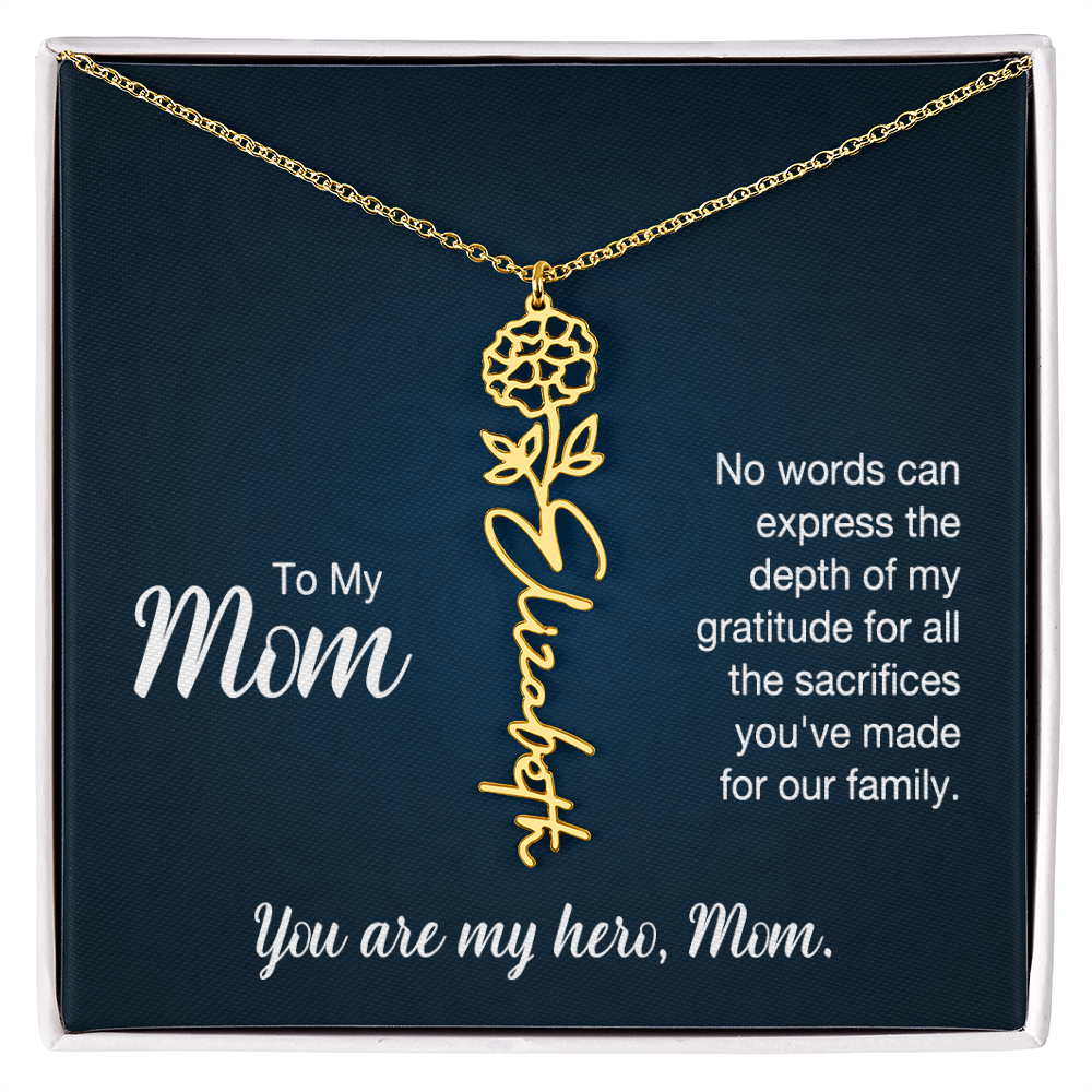 A gold floral filigree necklace with the name 'Elizabeth' engraved, presented on a dark blue gift card with sentimental text for 'Mom', in a standard black and white soft touch gift box.